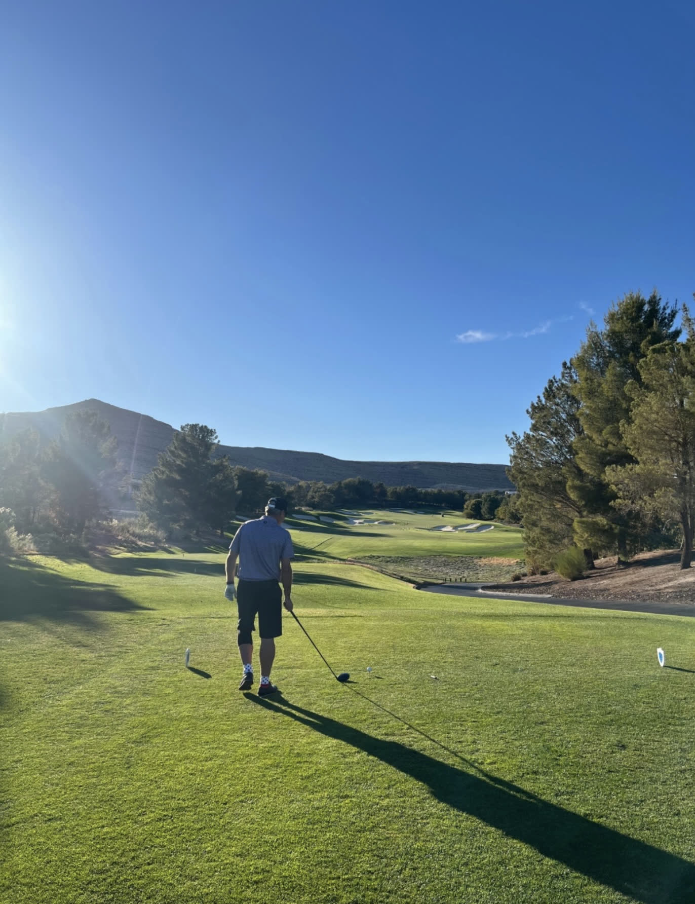 Golfer walking a fairway at sunrise